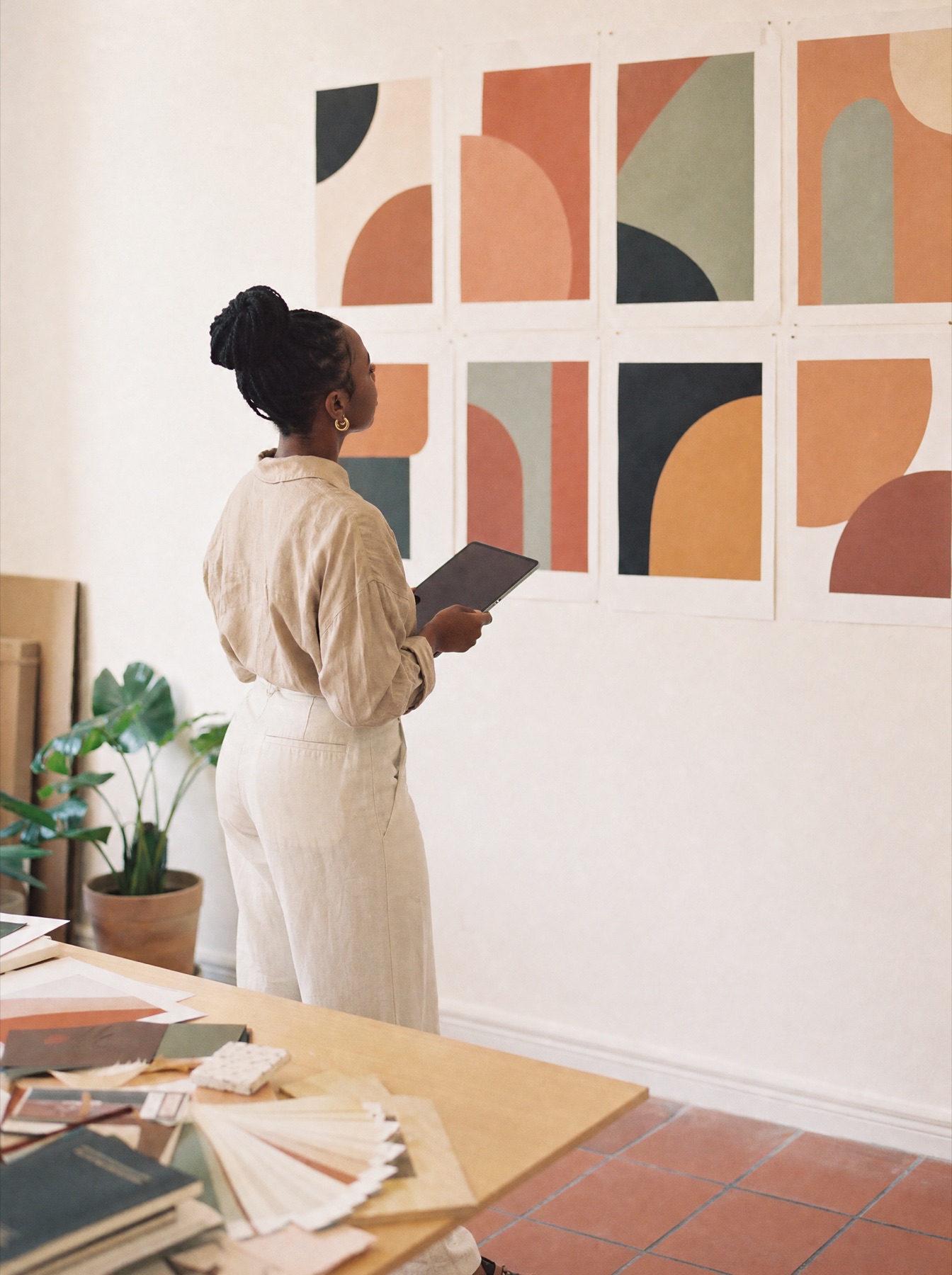 A designer reviewing poster proofs on a studio wall