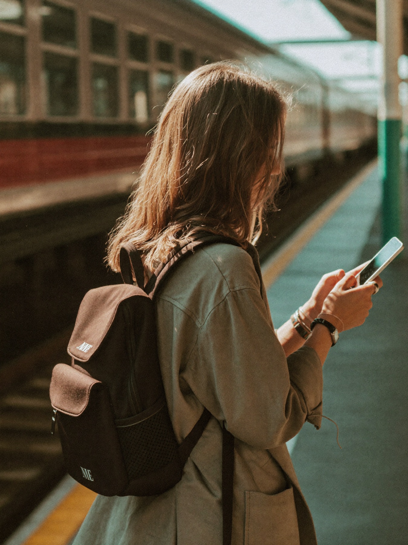 A traveller on a train platform checking her phone